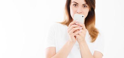 ritratto ritagliato di una giovane donna sorridente che tiene in mano un telefono cellulare isolato su sfondo bianco, ragazza in chat, concetto pubblicitario, spazio copia foto