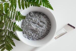 asciutto facciale argilla polvere per viso e corpo nel ceramica ciotola, superiore Visualizza. naturale cosmetici per casa o salone terme trattamento su bianca sfondo. spazio per testo. alto qualità foto