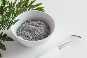 preparazione cosmetico fango maschera nel ceramica ciotola su bianca sfondo. avvicinamento struttura di facciale argilla emulsione. naturale cosmetici per casa o salone terme trattamento foto