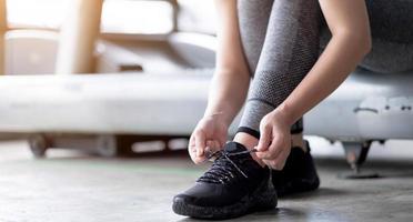 scarpe sportive. mani di donna che allacciano i lacci delle scarpe su scarpe da ginnastica alla moda foto