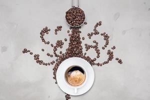 tazza di caffè nero con chicchi di caffè su sfondo bianco con copia spazio per il testo foto