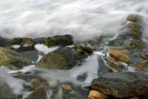turbolenza acqua di mare e roccia sulla costa foto