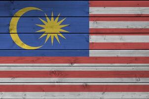 Malaysia bandiera raffigurato nel luminosa dipingere colori su vecchio di legno parete. strutturato bandiera su ruvido sfondo foto
