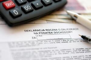 annuale dichiarazione di reddito imposta progressi, fossa-4r modulo su contabile tavolo con penna e polacco zloty i soldi fatture foto