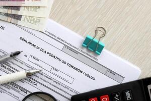 dichiarazione per imposta su merce e Servizi IVA-7k modulo su contabile tavolo con penna e polacco zloty i soldi fatture foto