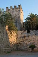 fortificazioni della città di rodi. vecchia torre in pietra e palme al tramonto. bellissimo punto di riferimento. dodecaneso, grecia. foto