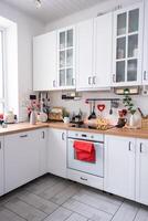 il interno di il cucina nel il Casa è decorato con rosso cuori per San Valentino giorno. arredamento su il tavolo, fornello, utensili, festivo umore nel un' famiglia nido foto