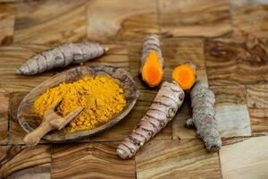 curcuma curcuma longa la spezia gialla su legno d'ulivo foto