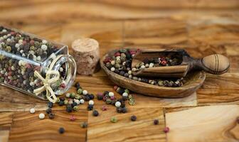 un' pila di grani di pepe su oliva legna foto