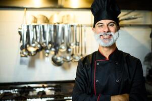 sorridente capocuoco nel professionale cucina foto