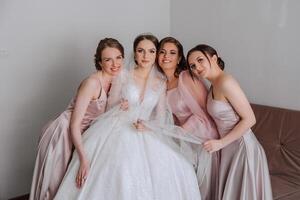 amici rallegrarsi con il sposa nel il mattina. essi prendere immagini, Sorridi, Aiuto il sposa allacciare sua vestire. foto