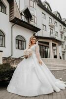 bellissimo sposa con un' nozze mazzo di fiori, attraente donna nel un' nozze vestito con un' lungo velo. contento sposa donna. sposa con nozze trucco e pettinatura. inverno nozze foto