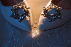 dettagli di il sposa. bellezza è nel il particolari. tacco alto bridal scarpe. oro nozze squillare con un' diamante. profumi. orecchini nozze nel particolari. foto