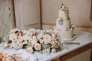 un' grande lussuoso multilivello nozze torta è decorato con fresco bianca rosa fiori nel il banchetto sala. nozze dolce sotto il sera luce. nozze arredamento. foto