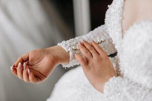 il sposa si allaccia il manica di sua nozze vestire. mattina di il sposa. preparazione. nozze fotografia foto