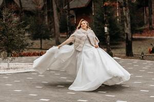 bellissimo sposa con un' nozze mazzo di fiori, attraente donna nel un' nozze vestito con un' lungo velo. contento sposa donna. sposa con nozze trucco e pettinatura. inverno nozze foto