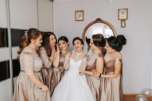 il damigelle d'onore Aiuto il sposa ottenere vestito. preparazione per il nozze. mattina di il sposa foto