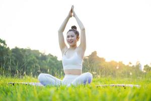 immagine di una donna asiatica che fa yoga all'aperto foto