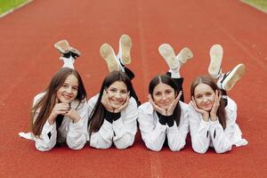 ritratto di Due adolescenziale ragazze nel casuale Abiti seduta nel un' stadio e in posa guardare a il telecamera. concetto di amicizia. un' momento di felicità. foto