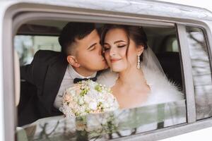 bellissimo sposa e sposo seduta nel un' elegante bianca macchina. bellissimo nozze. sorridente nozze coppia. il sposa e sposo bacio nel il auto foto