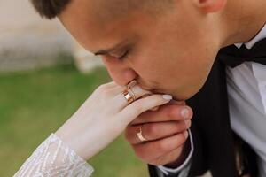 il sposo baci il mano di il sposa. ritagliata foto. nel essenziale particolari. tenerezza foto