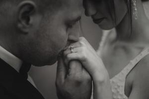 lei detto lui sì. un' giovane uomo baci il suo della moglie mano con un' oro squillo, proponente matrimonio. Fidanzamento di un' giovane coppia nel amore. concetto di amore e unità. foto