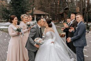 sposa e sposo abbracciare, in posa con gli amici. amici siamo avendo divertimento. contento momenti. nozze ritratto nel natura, nozze foto nel leggero colori.