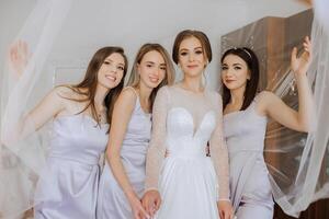 amici rallegrarsi con il sposa nel il mattina. essi prendere immagini, Sorridi, Aiuto il sposa allacciare sua vestire. foto