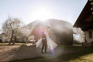 il sposa nel il braccia di il sposo. il sposo è Tenere il suo sposa nel il suo braccia e girando contro il sfondo di un' bellissimo parco. foto