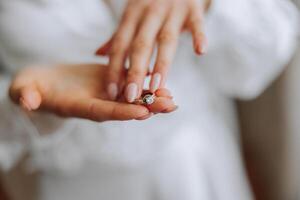 avvicinamento di un elegante diamante squillare su un' donna di dito con un' moderno manicure, luce del sole. amore e nozze concetto. morbido e selettivo messa a fuoco. foto