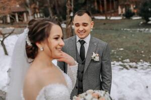 il sposo arriva su dietro a il sposa e abbraccia suo. sincero emozioni. un' camminare nel il foresta. inverno nozze foto