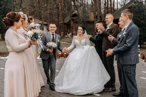 sposa e sposo abbracciare, in posa con gli amici. amici siamo avendo divertimento. contento momenti. nozze ritratto nel natura, nozze foto nel leggero colori.