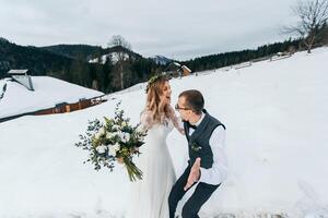 giovane coppia sposa e sposo giocando nel inverno natura contro il sfondo di nevoso montagne. per giocare palle di neve. salto. avere un' bene tempo ridendo. foto