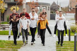 gruppo di molti contento adolescenti vestito nel casuale Abiti avendo divertimento e avendo divertimento vicino Università. concetto di amicizia, momenti di felicità. scuola amicizia foto