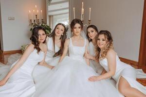 amici rallegrarsi con il sposa nel il mattina. essi prendere immagini, Sorridi, Aiuto il sposa allacciare sua vestire. foto