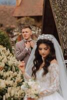 un' bellissimo giovane sposa, nel un' estate parco, passeggiate avanti di sua sposo. bellissimo nozze bianca vestire. passeggiate nel il parco. un' contento e amorevole coppia. foto