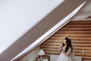 un' meraviglioso bellissimo ritratto di un' giovane sposa. bellissimo sposa con nozze trucco e gioielleria ghirlanda su lungo Riccio capelli. nozze foto modello con Marrone occhi nel un' bellissimo interno.