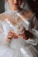 moda foto di un' bellissimo sposa con buio capelli nel un elegante nozze vestito e sbalorditivo trucco nel il camera su il mattina di il nozze. il sposa è preparazione per il nozze