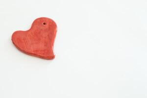 rosso cuore sagomato ceramica pezzo con bianca sfondo foto
