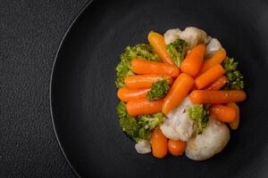 delizioso fresco verdure broccoli, cavolfiore, carote al vapore con sale e spezie foto
