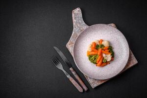 delizioso fresco verdure broccoli, cavolfiore, carote al vapore con sale e spezie foto