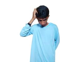 giovane riflessivo asiatico uomo Tenere mano su mento guardare pensieroso, indossare blu maglietta su bianca sfondo. foto