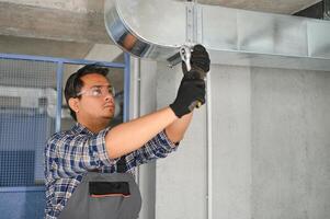 HVAC indiano lavoratore installare canalizzato tubo sistema per ventilazione e aria condizionata. copia spazio foto