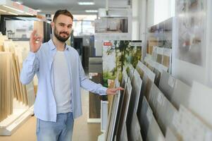 uomo la scelta piastrelle a edificio mercato foto