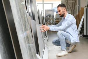 uomo la scelta ceramica piastrelle e utensili per il suo casa bagno foto