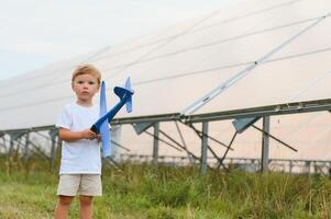 un' poco ragazzo è avendo divertimento vicino il solare pannelli. il concetto di solare energia. foto