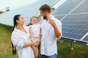 il concetto di rinnovabile energia. giovane contento famiglia vicino solare pannelli foto