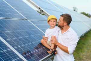 contento padre e il suo poco figlio siamo a piedi vicino il solare pannelli. il concetto di verde energia. foto