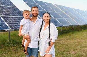 contento famiglia vicino solare pannelli. alternativa energia fonte foto