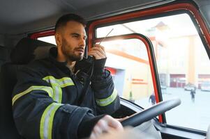 pompiere utilizzando Radio impostato mentre guida fuoco camion foto